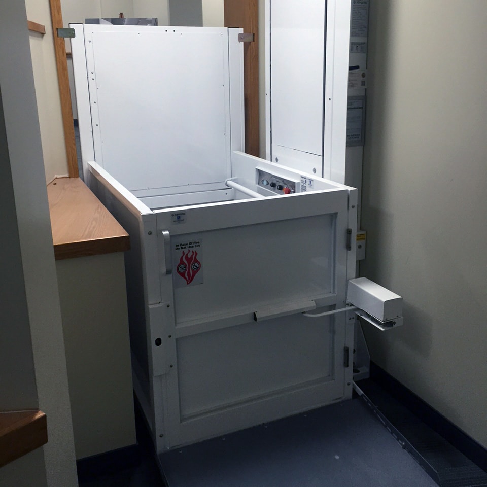 A white wheelchair lift inside a room.